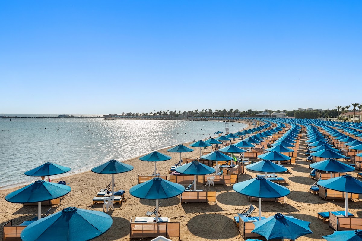 Pickalbatros Dana Beach Resort: песчаный пляж с шезлонгами и зонтиками